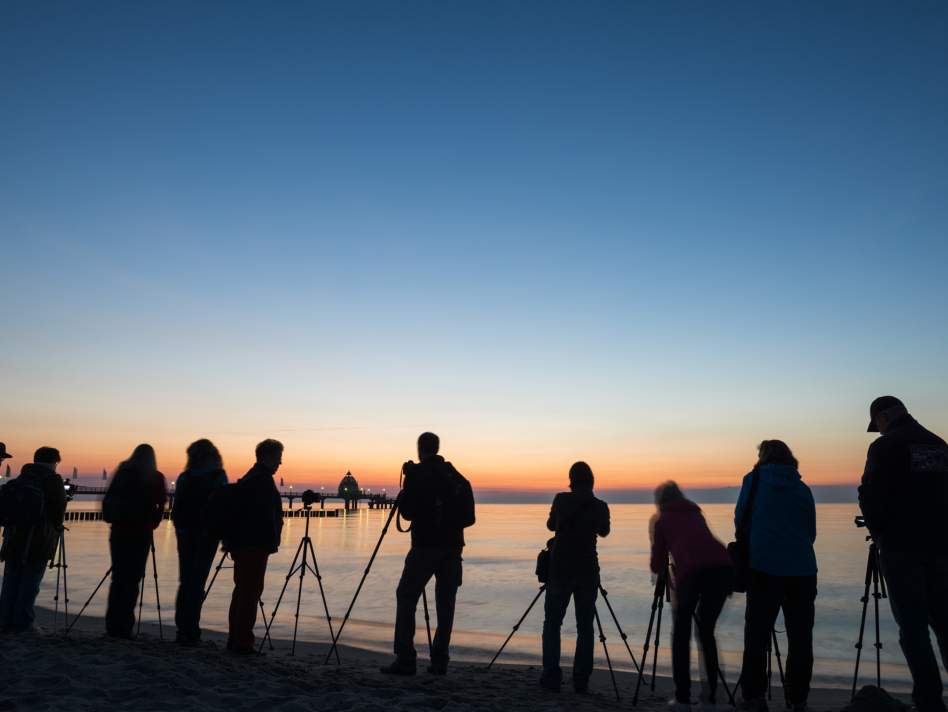 Fotografengruppe zum Sommenuntergang am Strand